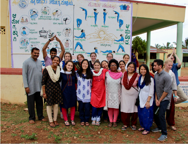 Photo of the Summer 2017 Cohort in SVYM, in front a diagram on yoga designed by a student from our 2011 cohort